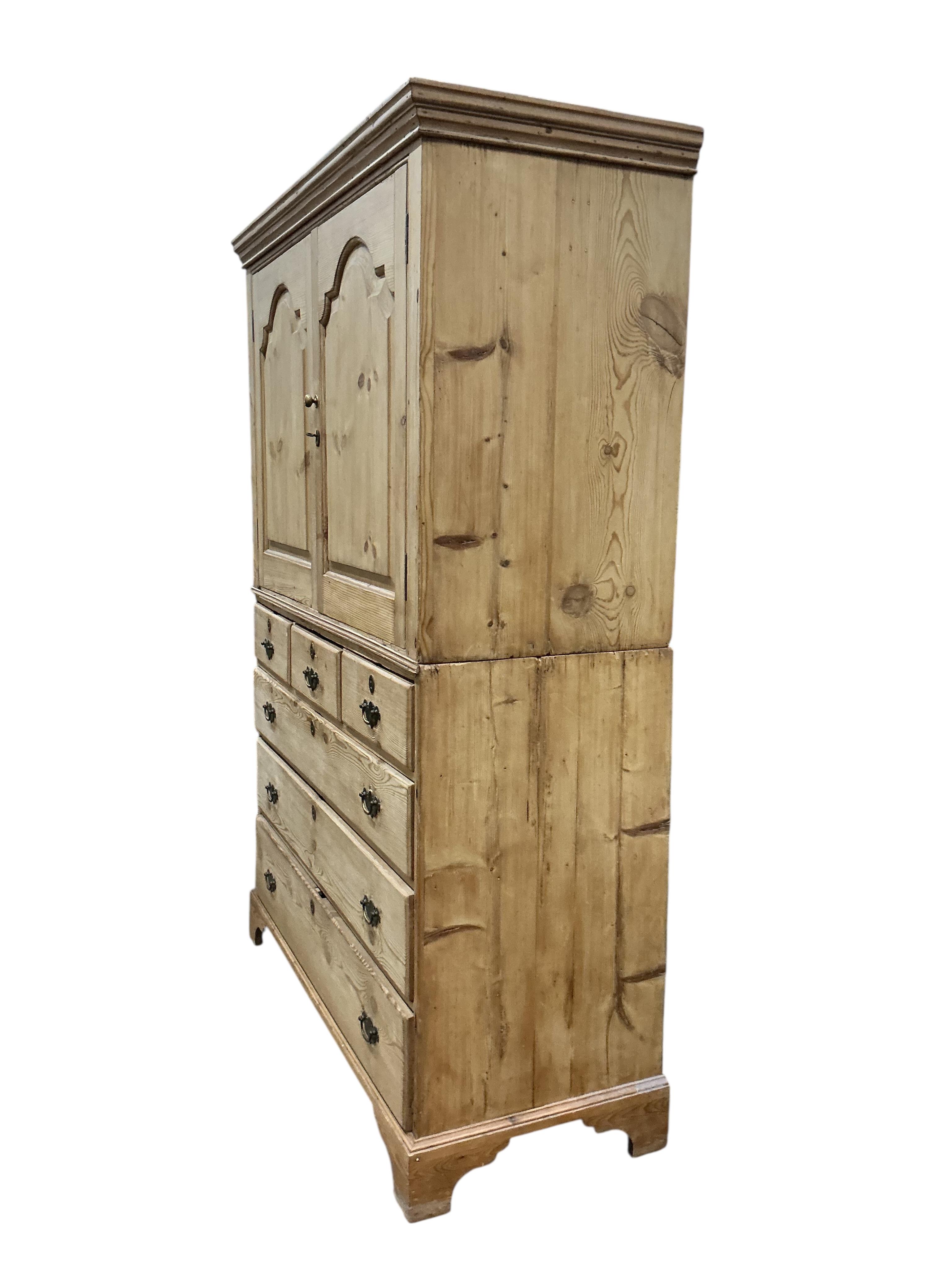 An early 19th century pine two part press cupboard, width 125cm, depth 54cm, height 191cm